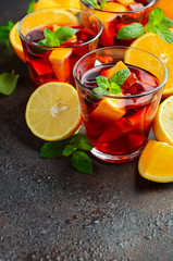 Fototapeta premium Spanish sangria cocktail and ingredients on dark concrete or stone background, selective focus, copy space.