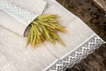 Shot of barley and flowers rolled in a linen towel with snow white lace trim.