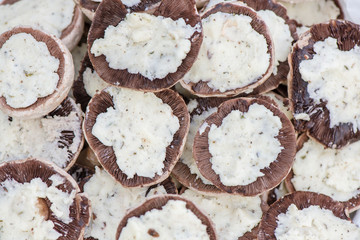 Preparing mushrooms for barbecue on holiday. Mushrooms with cheese spread in bowl. Cooking vegetables. Delicious meal for vegetarians and vegans