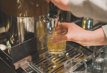 Woman pours a drink in the diner with self-service.
