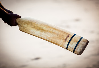 boy playing cricket at sunset on tropical beach in Sri Lanka