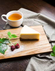 Italian dessert cheesecake with raspberry  and a cup of coffee on a wooden board