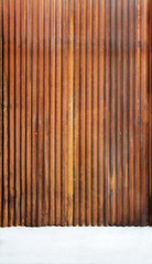 Corrugated zinc fence with old rusty surface brown with cement floor for the background.