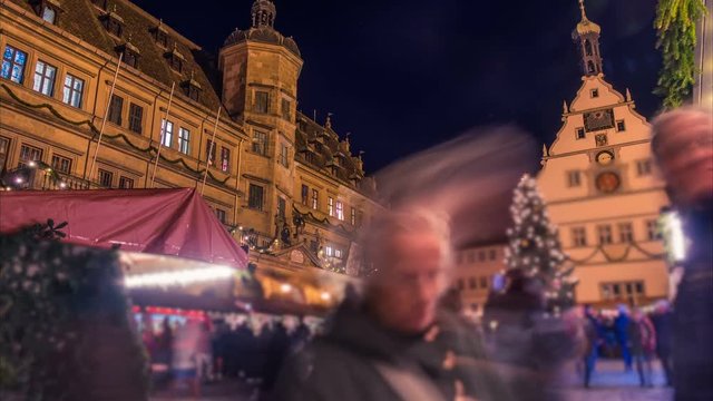 Rothenburg ob der Tauber Christmas market. Blurred crowd of people. Night time lapse. Zoom effect.