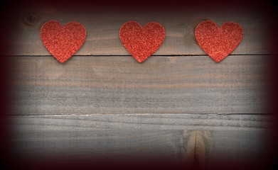Red hearts on wood background with vignette