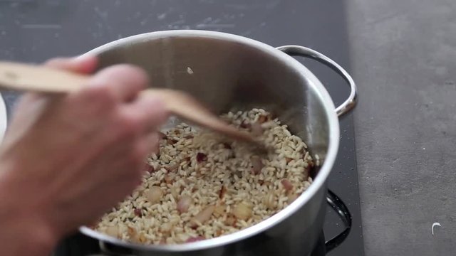 Risotto kochen auf modernem Herd, Detailaufnahme Abl&ouml;schen mit Wei&szlig;wein, Video HD 1080
