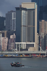 Tours d'immeubles sur le port de Hong Kong face à l'île de Kowloon avec bateau rentrant de la pêche. Mer de Chine, Asie.