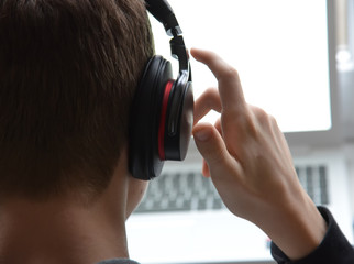 young man in headphones working on laptop