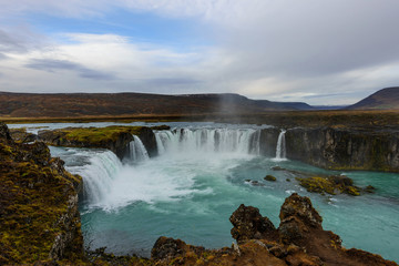 Fototapeta na wymiar Godafoss, waterfall of the gods, is one of the most spectacular waterfalls in Iceland. Amazing landscape at sunrise. Popular tourist attraction. Unusual and picturesque scene.