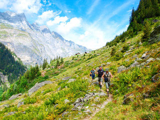 Young hikers trekking in alps, Switzerland, with mountains in the background