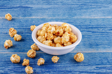 Popcorn with caramel on a blue wooden background