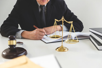 Gavel on wooden table and Lawyer or Judge working with agreement in Courtroom theme, Justice and Law concept