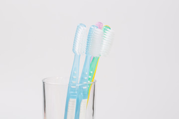 Five toothbrushes in glass - family set of toothbrushes isolated on white background