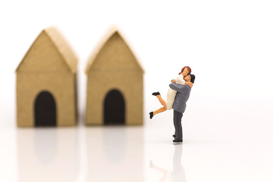 Miniature couple, couple hugged area front of house.  Used in the Valentine's day concept.