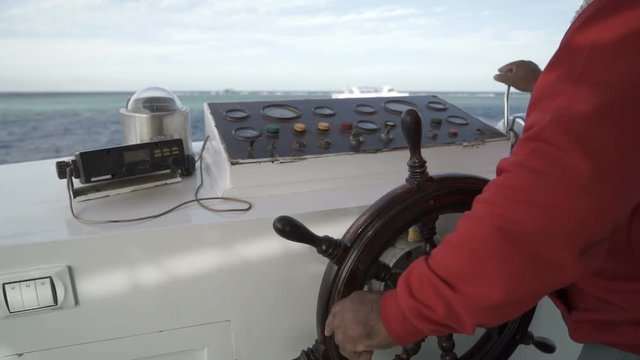 Captain operate an ancient ship steering wheel. Close up