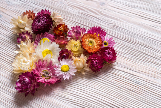 Heart made from flowers on wooden background