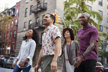 Fototapeta na wymiar Group Of Friends Walking Along Urban Street In New York City