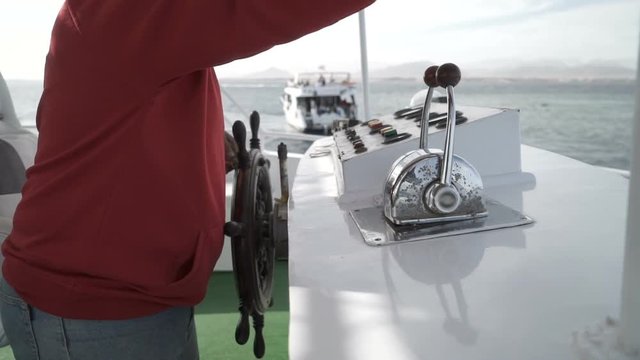 Captain operate an ancient ship steering wheel. Close up