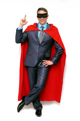 Super hero man showing by his index finger on copy space above him isolated on white background.