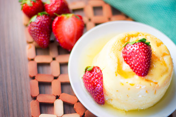 Sobremesa de morango com pudim servido em uma tigela.