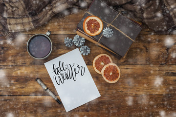 Beautiful composition on a winter theme with a mug of hot tea, a plaid, a diary and a pen.