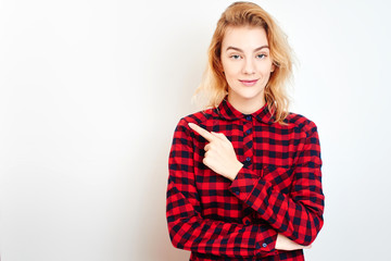 A young blonde girl in red shirt pointing his finger in the background