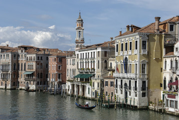 Naklejka premium Colorful facades of old medieval and historical houses along Grand Canal in Venice, Italy. Venice is situated across a group of 117 small islands that are separated by canals and linked by bridges