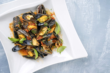 Traditional Italian blue mussel in white wine sauce as close up on a plate with copy space right