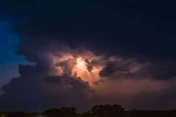 flash of lightning on a heavy cloudy background bringing thunder bolts