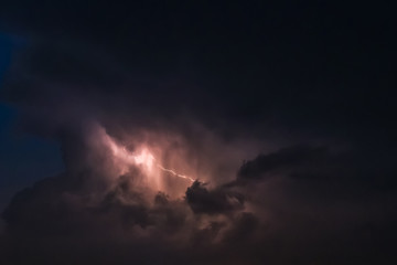 Fototapeta na wymiar flash of lightning on a heavy cloudy background bringing thunder bolts