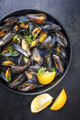 Traditional barbecue Italian blue mussel in white wine as top view in a casserole