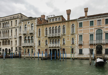 Fototapeta na wymiar Colorful facades of old medieval and historical houses along Grand Canal in Venice, Italy. Venice is situated across a group of 117 small islands that are separated by canals and linked by bridges