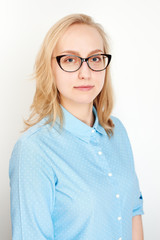Portrait of business girl on a white background in a blue shirt and glasses