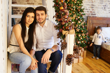 Obraz premium A young family in the apartment decorated for Christmas
