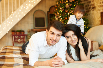 A young family in the apartment decorated for Christmas