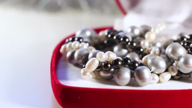 Black and White Pearls in Red Gift Box Close Up Macro.