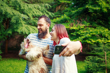 Happy couple making selfie with dog