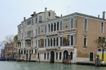 Naklejka premium Colorful facades of old medieval and historical houses along Grand Canal in Venice, Italy. Venice is situated across a group of 117 small islands that are separated by canals and linked by bridges