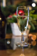 a filled wineglass in front of christmas decoration