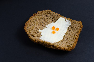 A slice of bread anointed with oil and red caviar