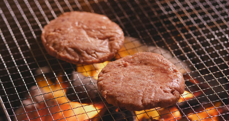 Grilling burger on BBQ fire
