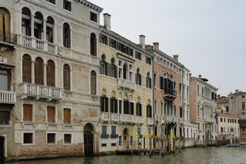 Fototapeta na wymiar Colorful facades of old medieval and historical houses along Grand Canal in Venice, Italy. Venice is situated across a group of 117 small islands that are separated by canals and linked by bridges