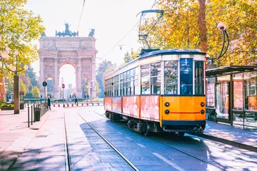 Fotobehang Milaan Beroemde vintage tram in het centrum van de oude stad van Milaan in de zonnige dag, Lombardia, Italië. Boog van Vrede, of Arco della Pace op de achtergrond.