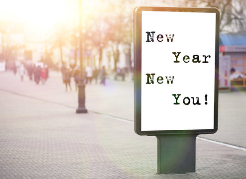 new year new you! text on an advertising banner, city street, sun rays - Powered by Adobe