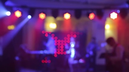 Background of the dance is blurred people dancing in a nightclub. Blue and purple colors