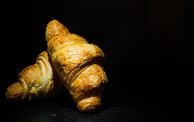 two croissants on dark wooden background. with copy space.