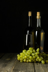 Glass bottle of wine with corks on wooden table background