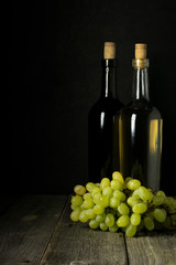 Obraz premium Glass bottle of wine with corks on wooden table background