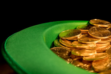 Pile of pure gold coins inside green hat St Patricks Day