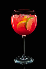 Big round wine glass with citrus sangria on black background with reflection